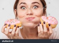 stock-photo-close-up-portrait-of-a-satisfied-pretty-girl-eating-donuts-isolated-over-white-bac...jpg